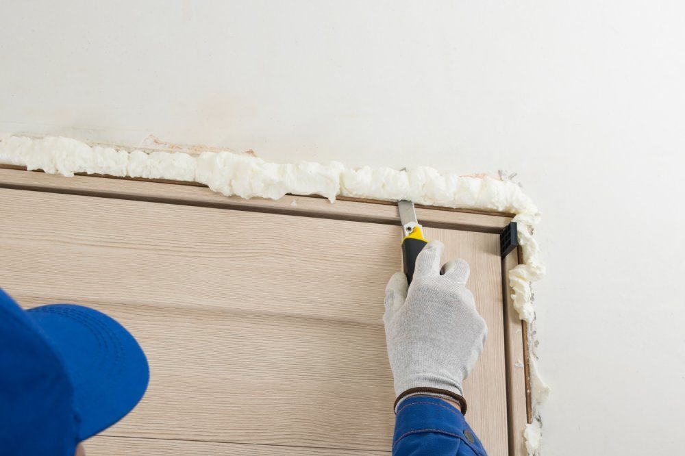 Entfernen von unnötigem getrocknetem Befestigungsschaum aus dem Türschlitz.